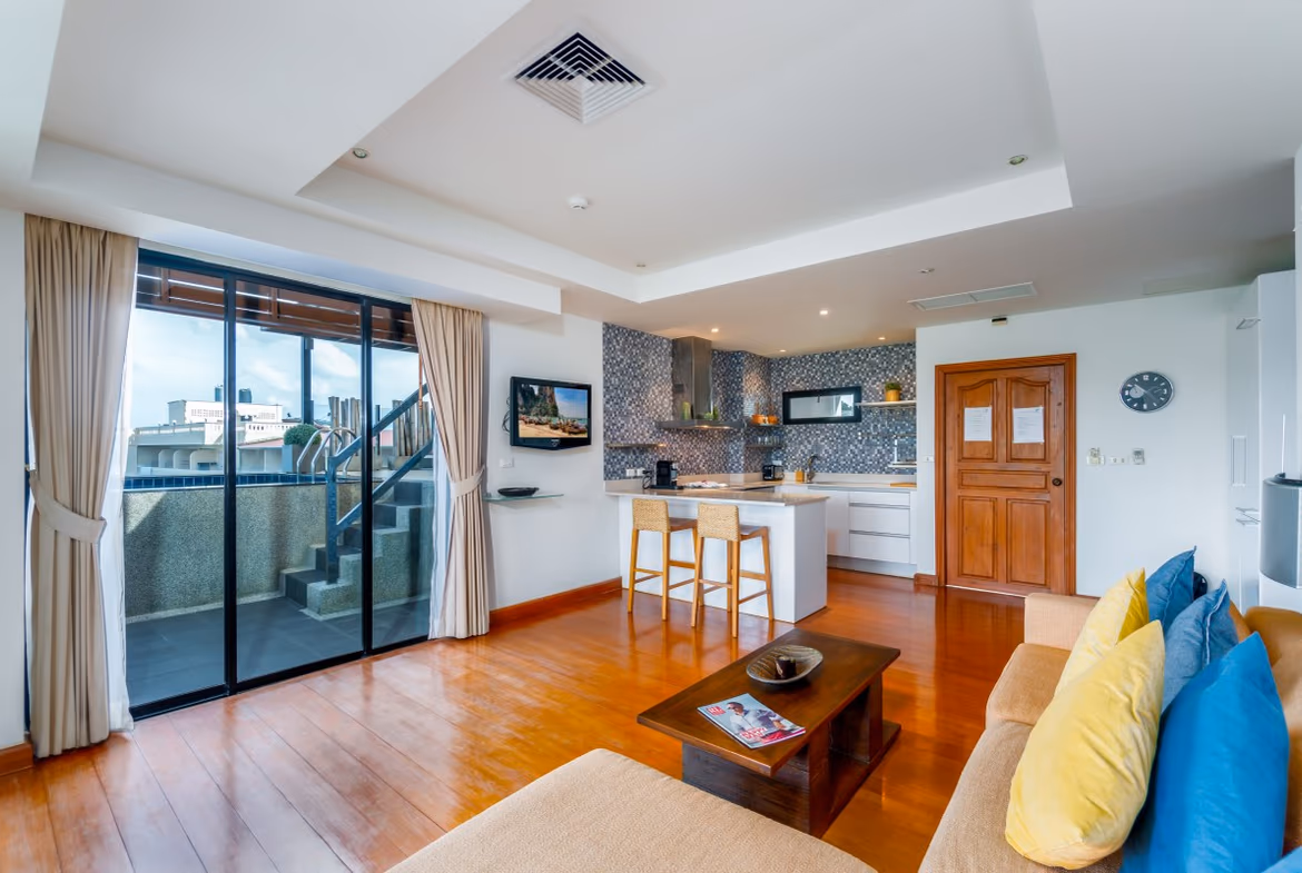 A spacious open-plan living area with modern furnishings and a view of the private pool.