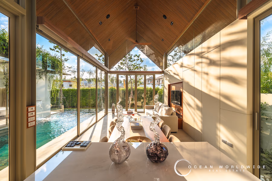Exterior view of a modern villa with a private swimming pool and a manicured lawn.