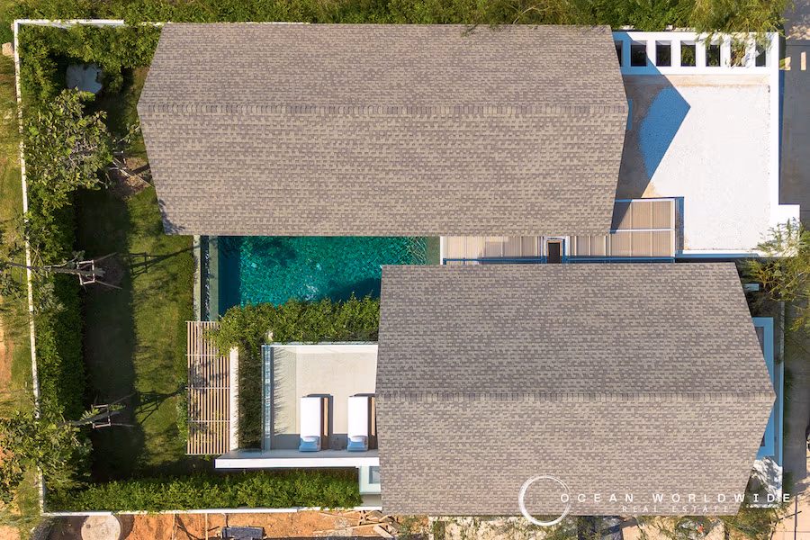 A spacious living area with large windows opens to a private pool and patio.