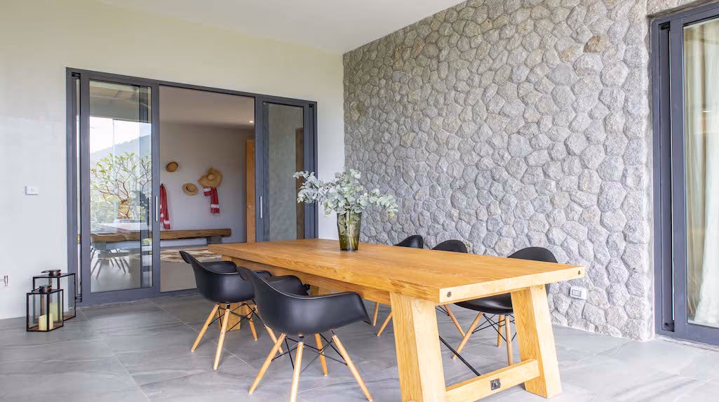 A spacious outdoor patio with a swimming pool overlooking a mountainous landscape.