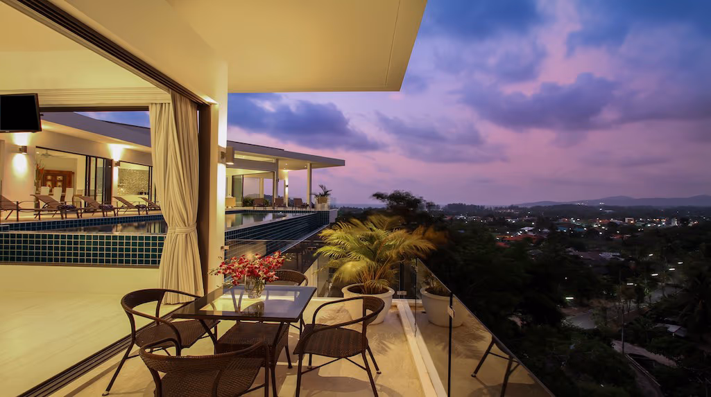 A spacious bedroom with a king-sized bed and a balcony overlooking a tropical garden.