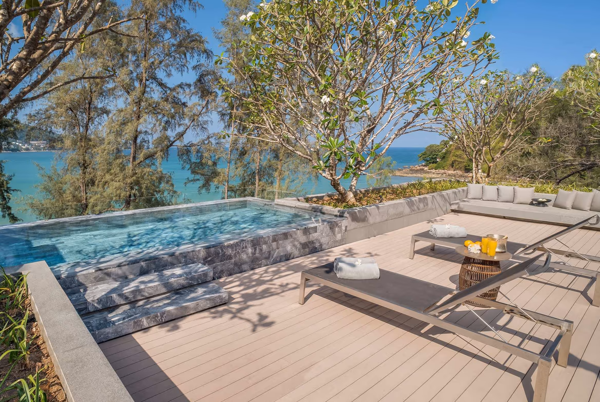 Exterior view of a 2-bedroom condominium in Kamala, featuring beachfront access. The luxury building has several balconies overlooking the water.