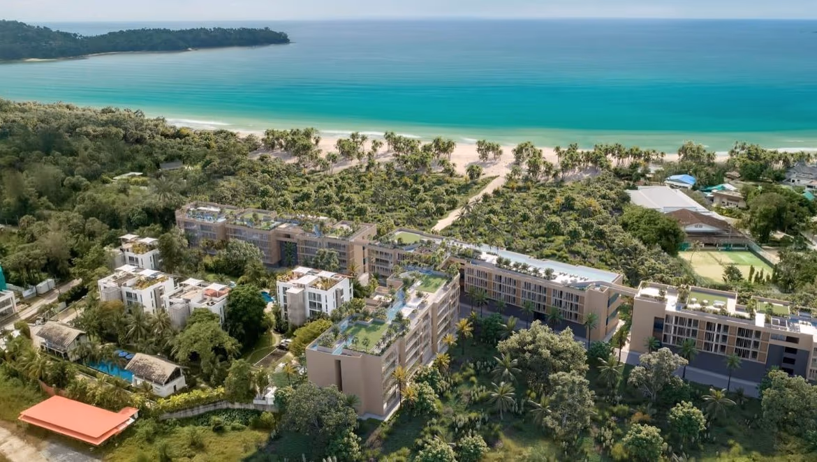 Exterior view of a new 2-bedroom condominium in Thalang, located near the beach. The building appears modern against a sunny sky.