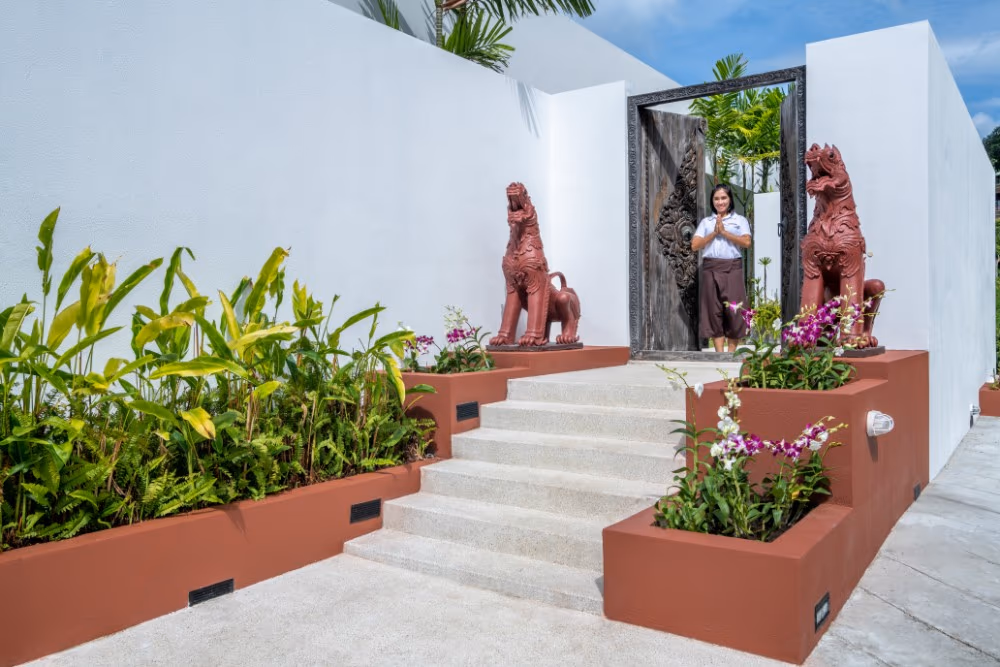 This image likely shows an outdoor swimming pool overlooking the ocean with palm trees.