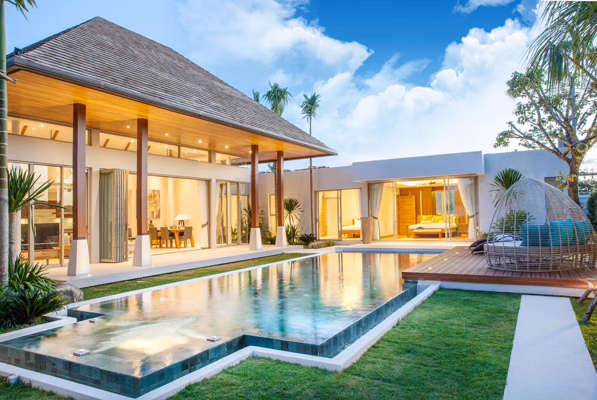 The living area overlooks an outdoor infinity pool and a tranquil lake.