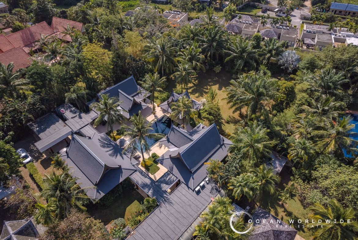 The photo likely shows a private swimming pool surrounded by tropical vegetation and outdoor seating.