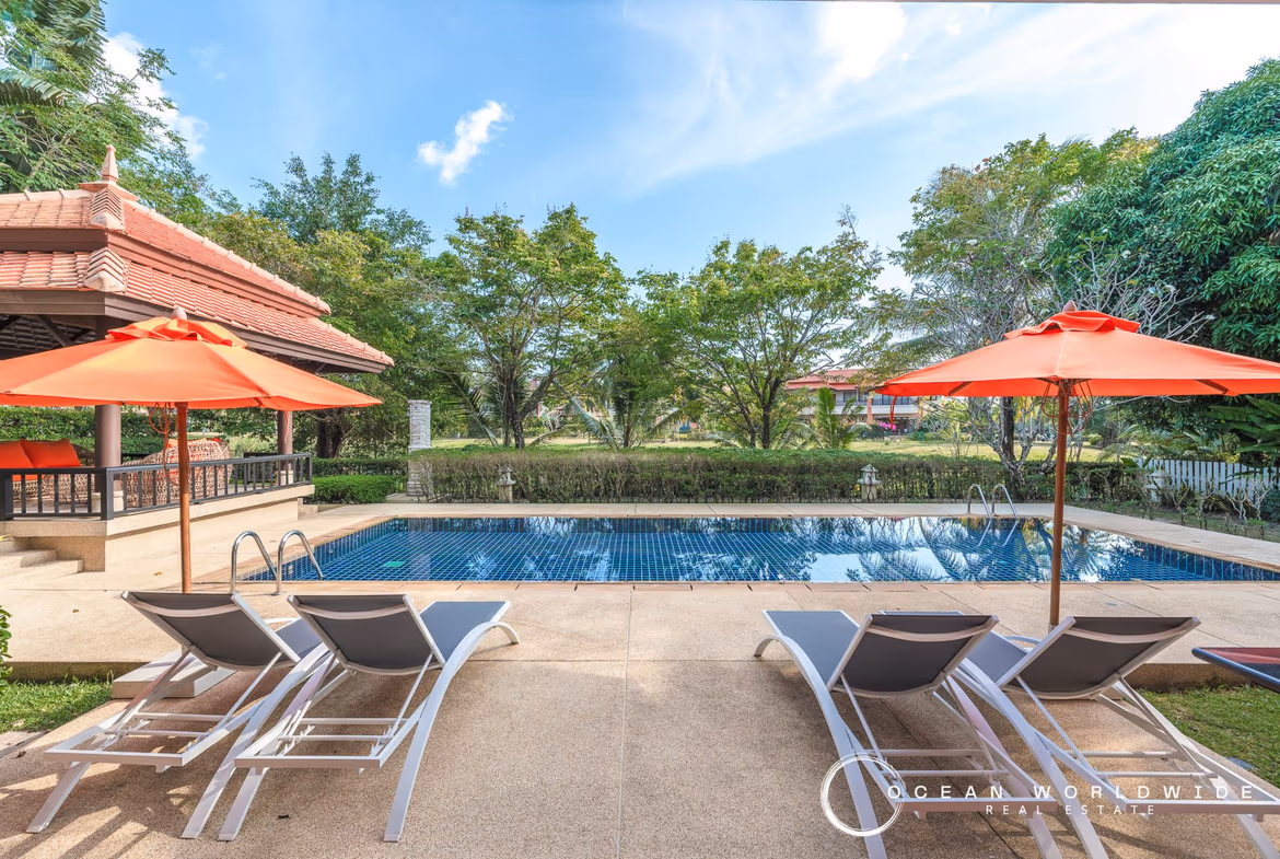 An outdoor patio with a swimming pool and a view of a lake.