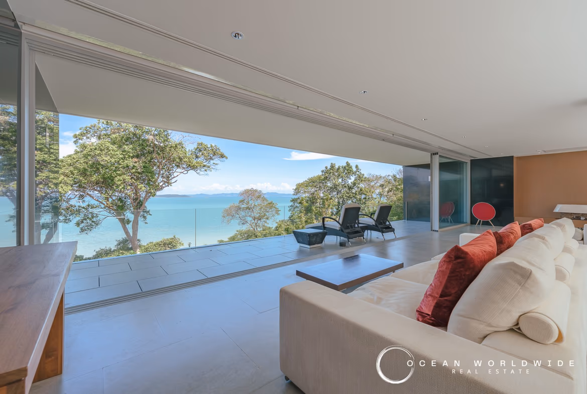 A spacious living area with modern décor and large windows overlooking the ocean.