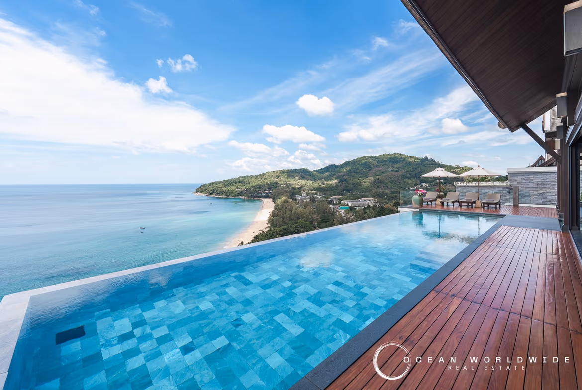 An infinity pool overlooks the ocean at sunset from a luxury villa.
