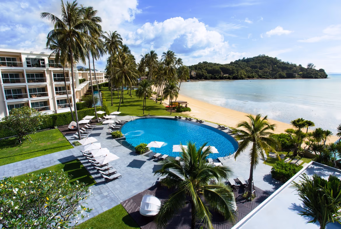 A luxury beachfront hotel in Panwa, Ao Yon, features contemporary hotel buildings with multiple balconies overlooking the ocean.
