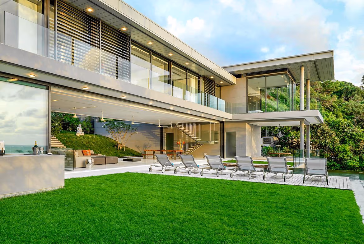 A spacious living room with large windows offers a panoramic view of the sea.