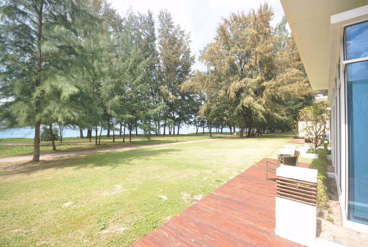 The photo shows a private pool surrounded by lush tropical landscaping and a partially visible building.