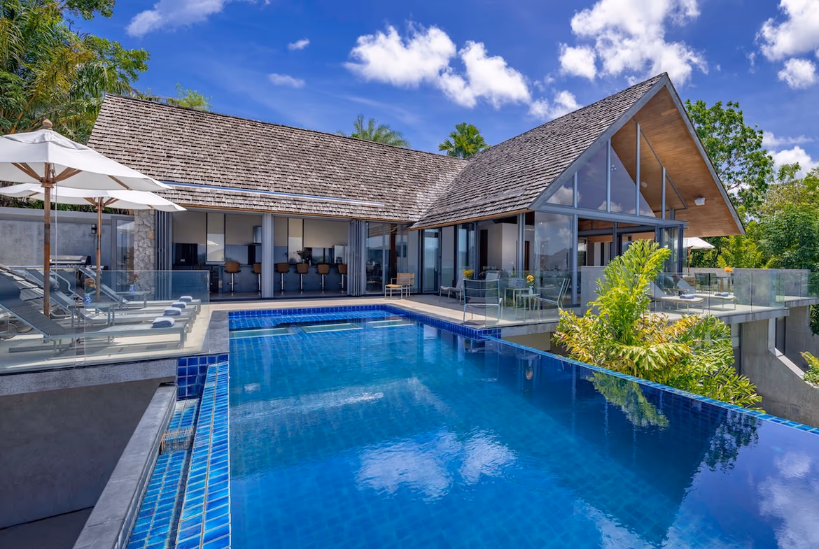A spacious outdoor dining area overlooks the ocean and a swimming pool.