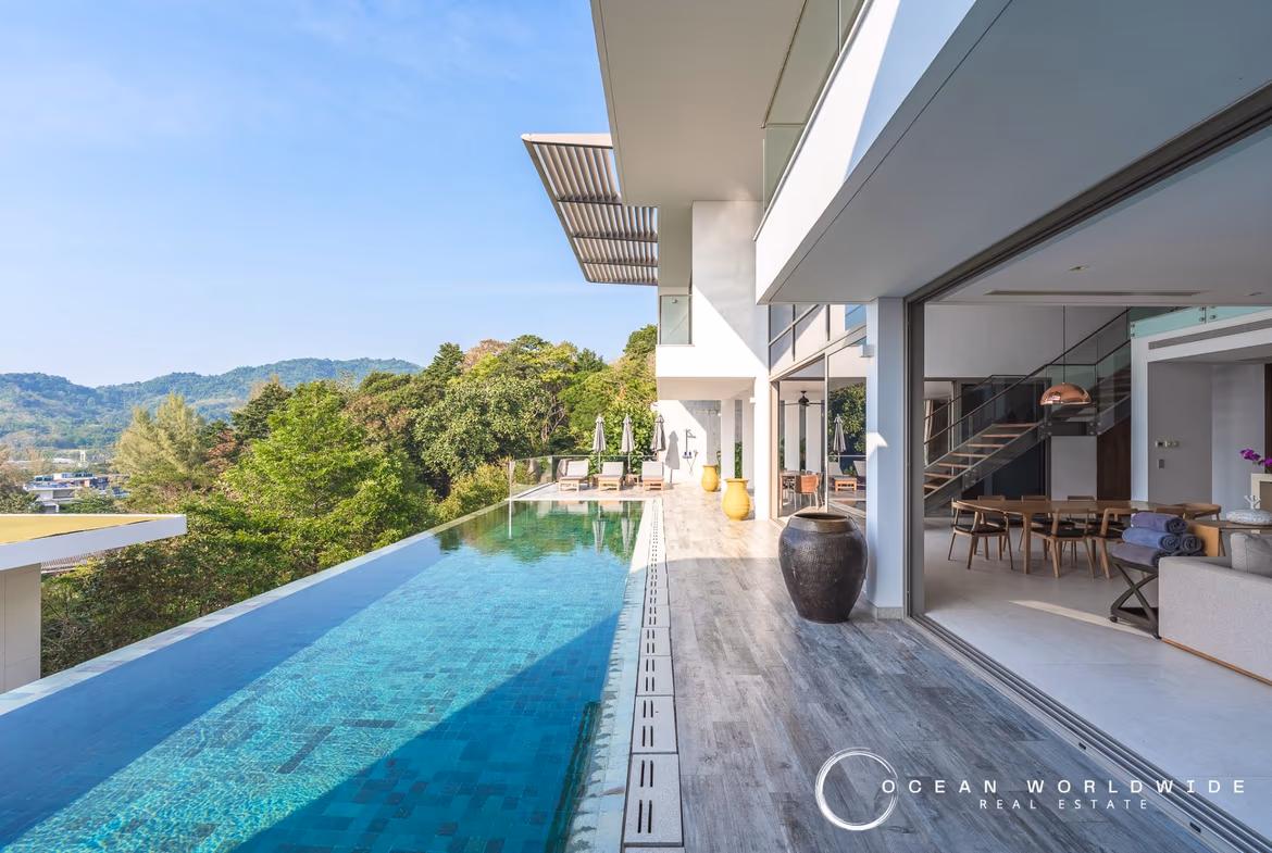 A balcony offers a panoramic view of the ocean and coastline.
