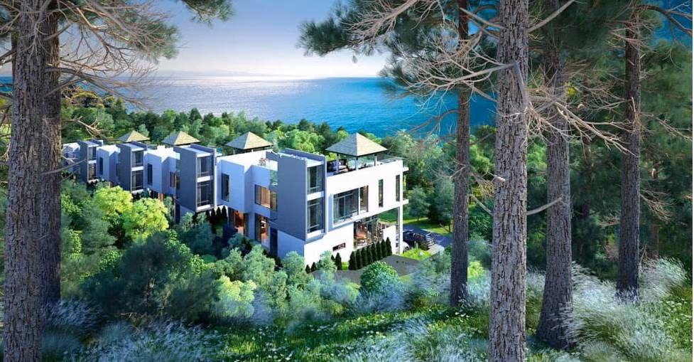 A modern living room with a gray sectional sofa, a white coffee table, and a view of a patio with a swimming pool.