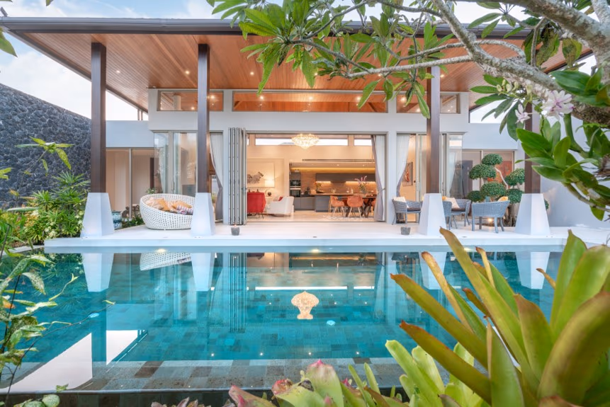A modern bedroom with minimalist decor and a large window overlooking a lush garden.