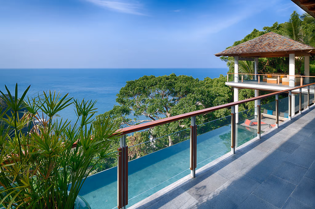 A bedroom with a large window overlooking the ocean.