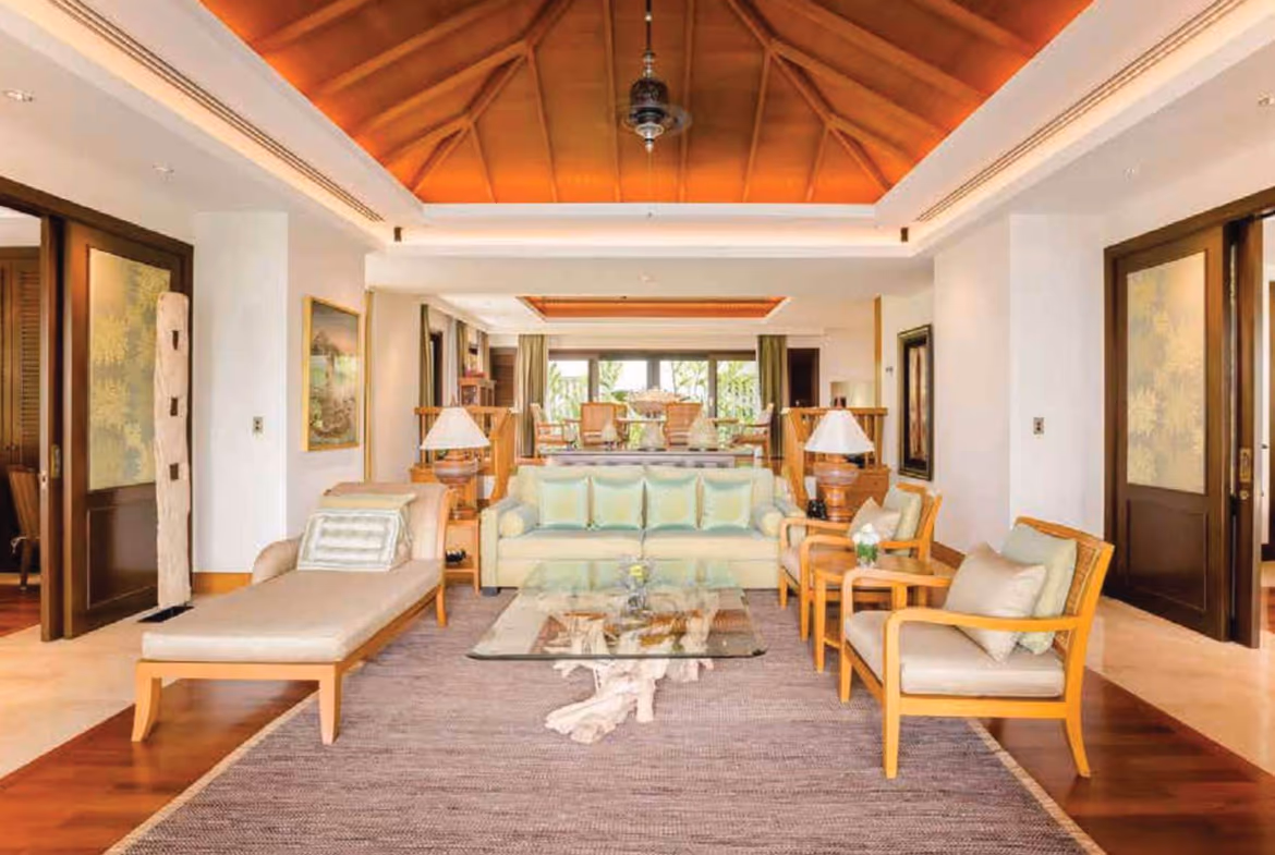 A spacious living area with modern furnishings and direct access to a private pool.