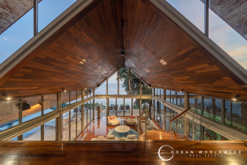 A spacious living room with large windows offers a panoramic ocean view.
