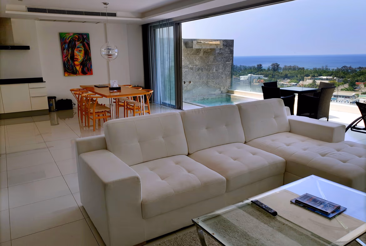 An expansive balcony offers panoramic ocean views, with visible islands in the distance.