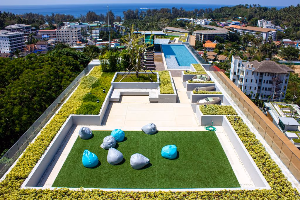 A minimalist high-rise condominium with panoramic views offers a large bedroom overlooking a coastline and ocean.