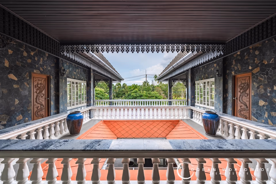 A 4-bedroom villa in Cherngtalay, Thailand, with a traditional Thai-style roof and a large, flat lawn.
