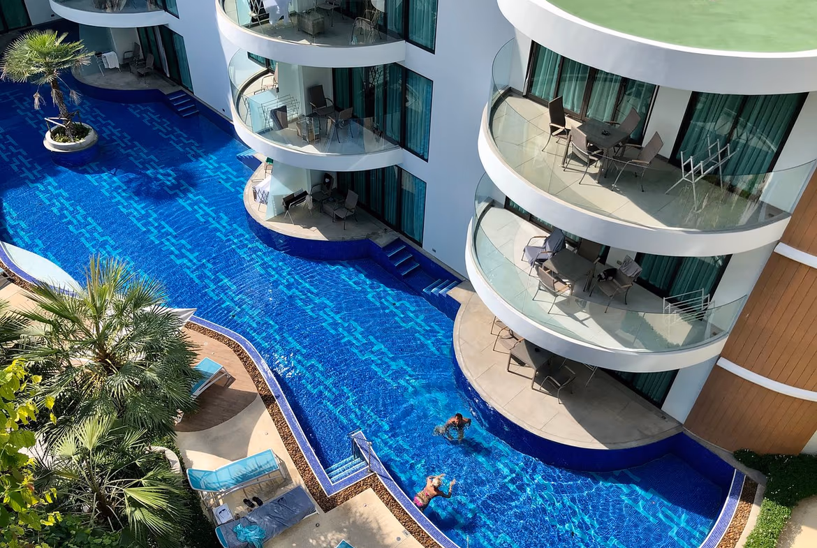 An expansive balcony overlooks a tropical landscape with ocean views.