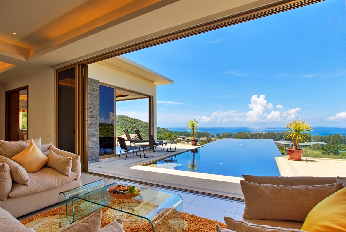 A spacious infinity pool overlooks the ocean, with lounge chairs and a covered patio for relaxing.