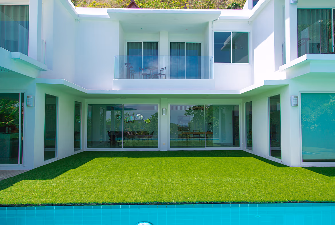 A panoramic view of the coastline with a pool deck in the foreground.