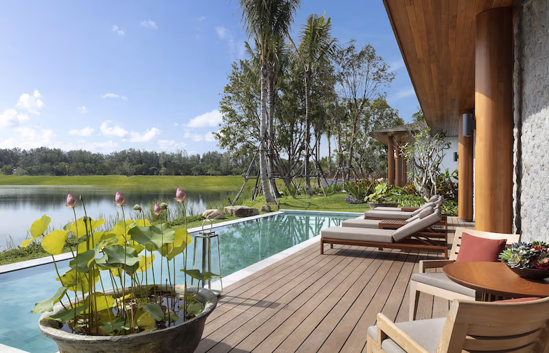 An outdoor swimming pool with an ocean view.