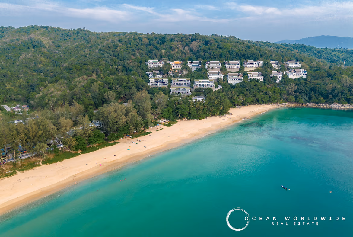 A large, modern living space with sliding glass doors opening to a balcony and a partial sea view.