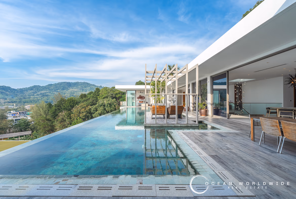 This is a four-bedroom villa in Thalang, featuring multiple balconies and a sea view. The property has a modern design with large windows.