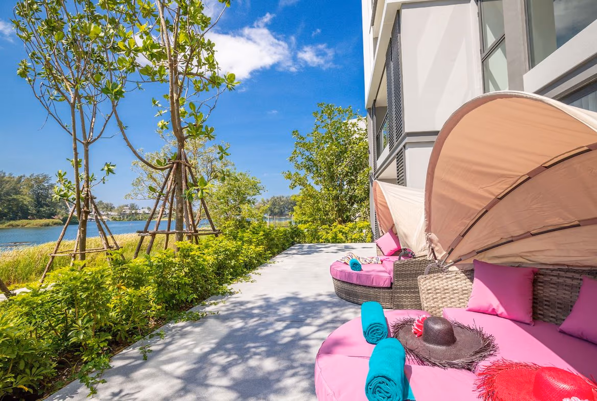 Exterior of a three-bedroom condominium in Phuket, featuring several balconies overlooking a calm lagoon.