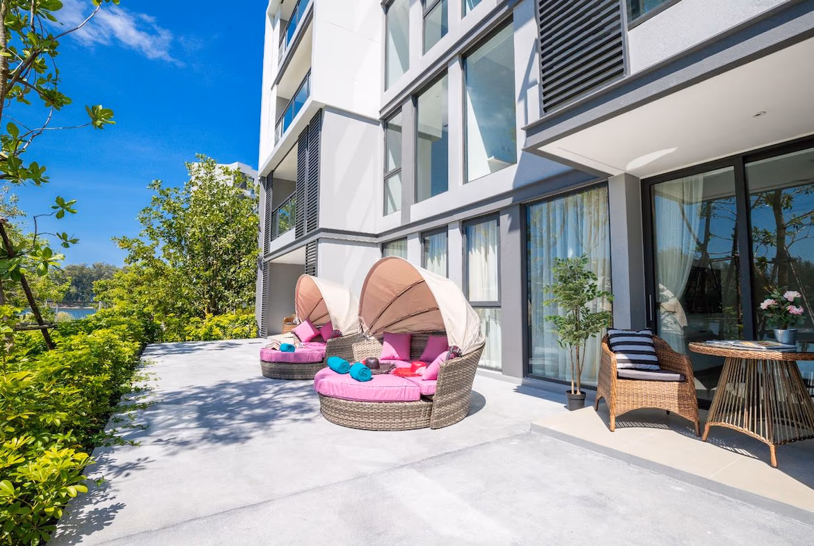 A bedroom with an open balcony overlooking a lagoon.