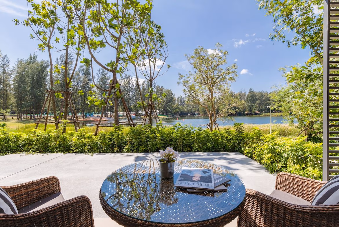 A spacious living area with large windows overlooks a serene lagoon.