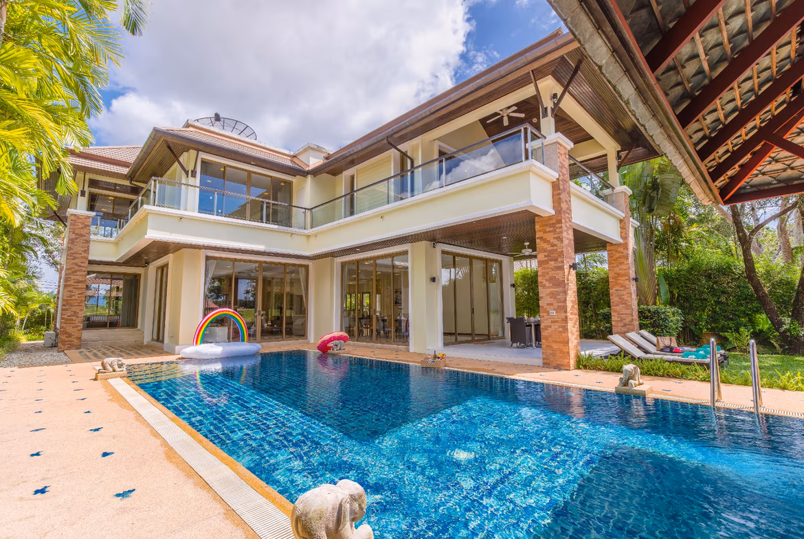 An infinity pool overlooks an ocean and mountainous coastline.