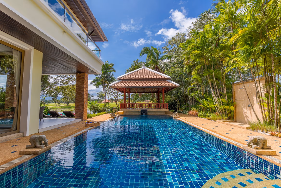 A spacious, well-lit living area with modern furnishings and large windows overlooking a golf course.