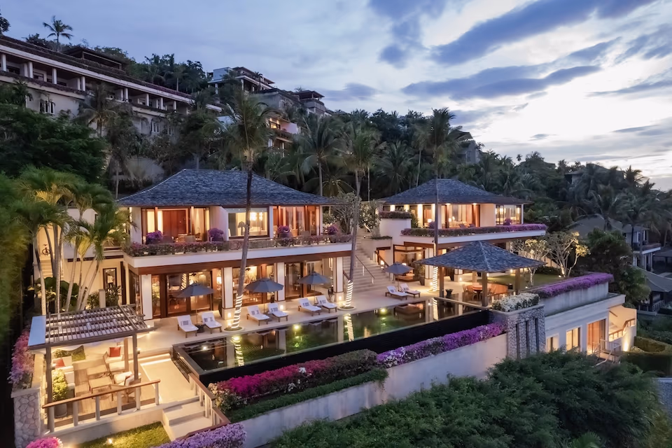 Hillside estate of villas lit at twilight above Kamala