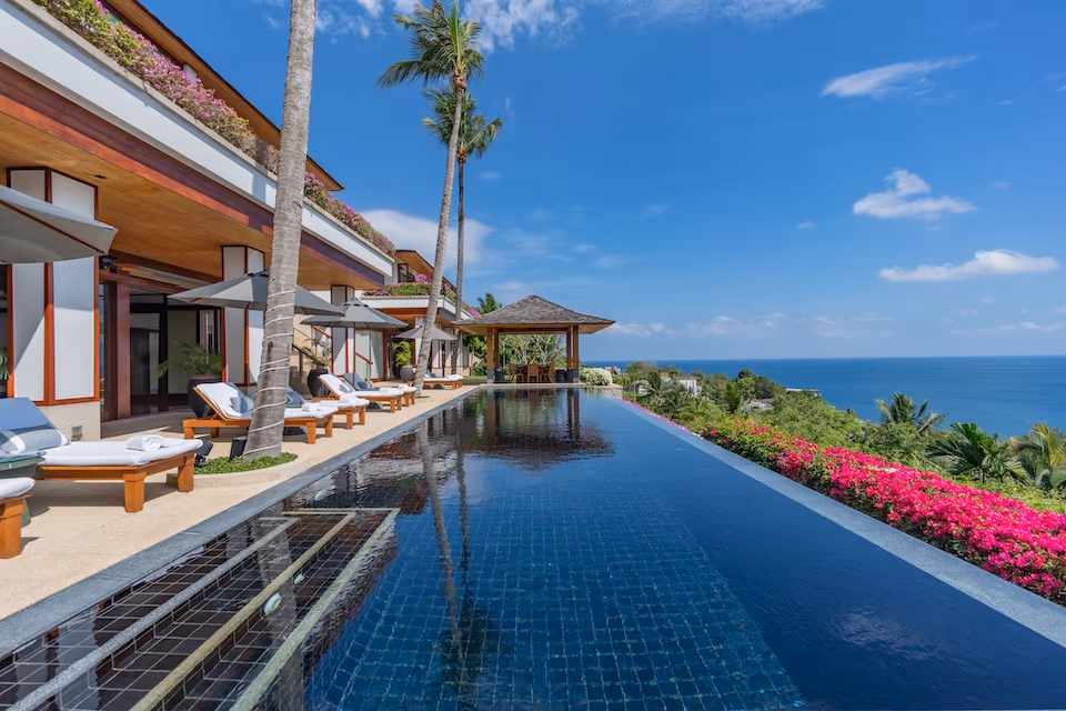 A spacious bedroom with a private balcony overlooking the ocean.