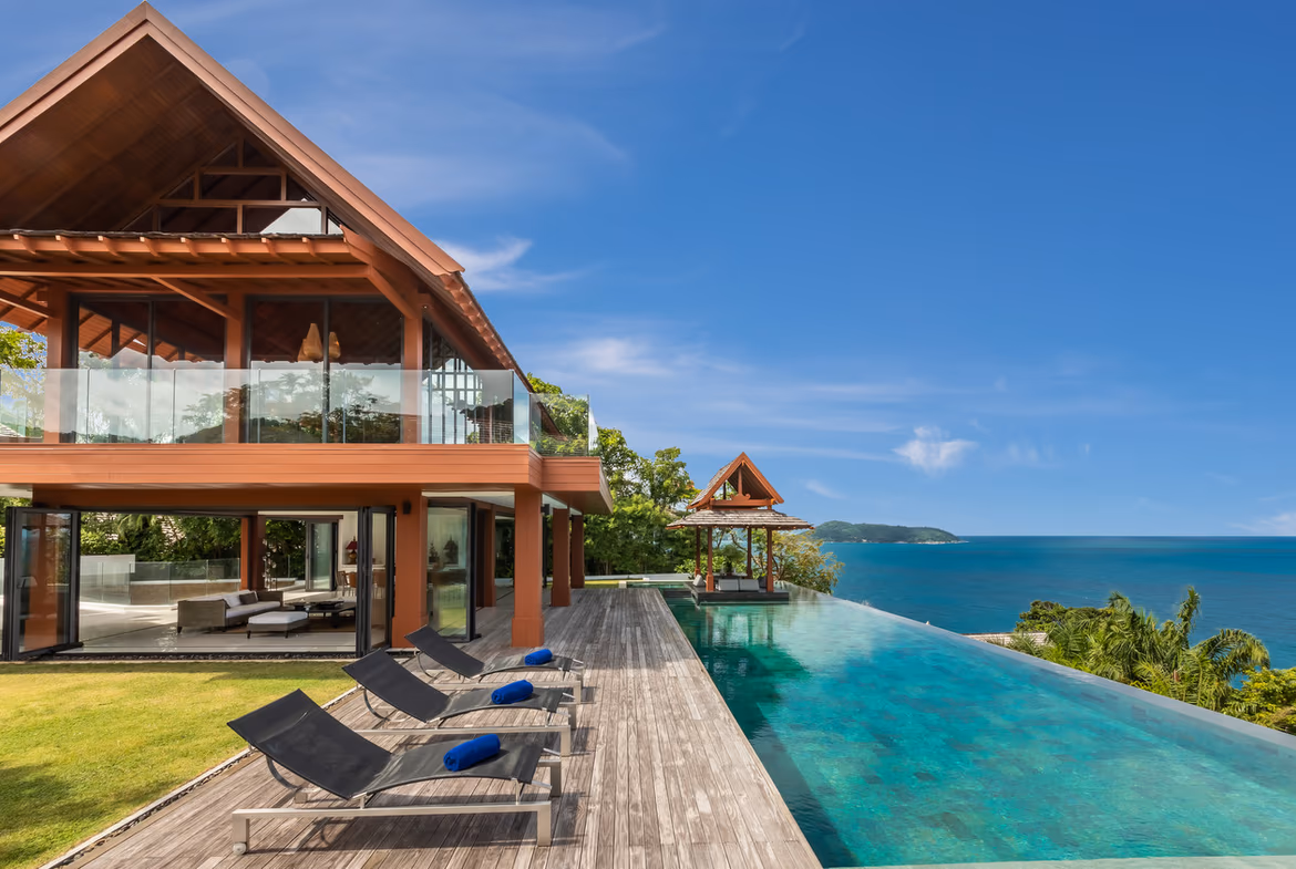 An exterior shot of a modern villa with an infinity pool overlooking the ocean.