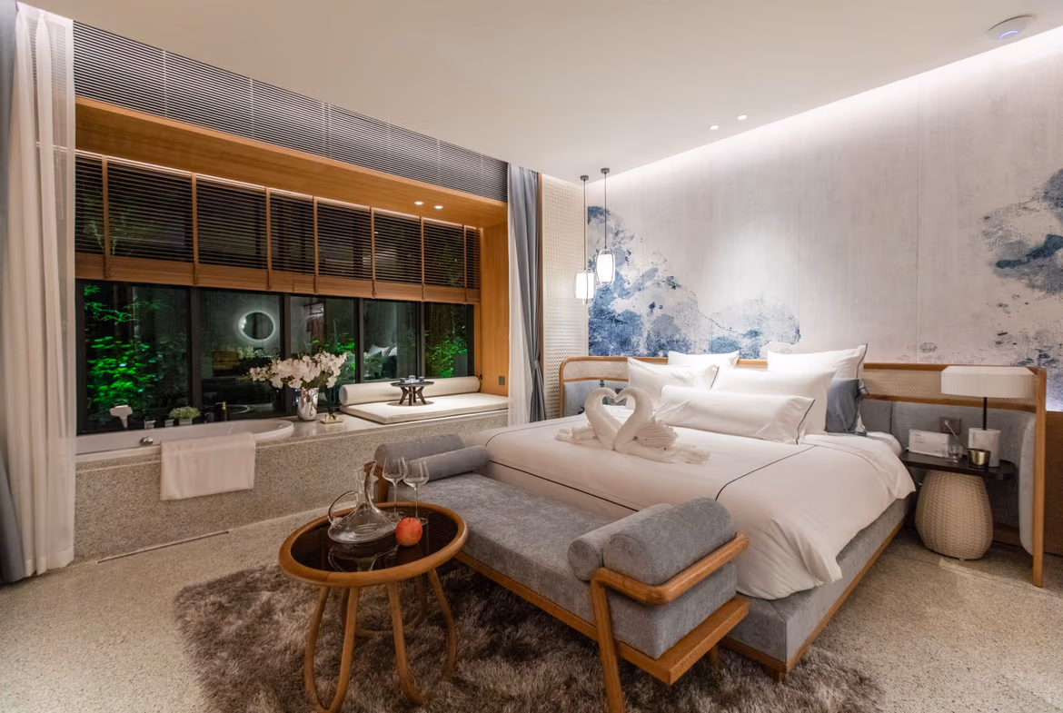 A spacious, modern living room with a large sofa and floor-to-ceiling windows offering