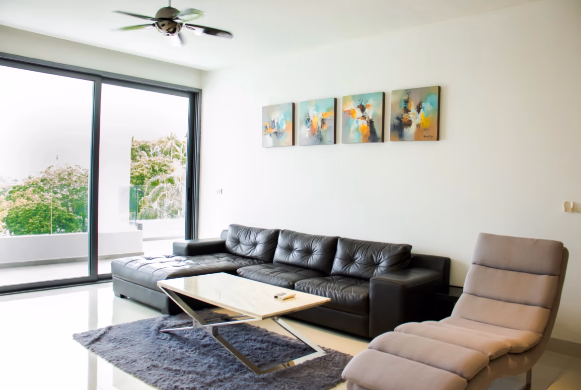 Two-bedroom condominium in Surin, featuring a gated community and partial sea views. The building has a modern, multi-story design with prominent balconies.