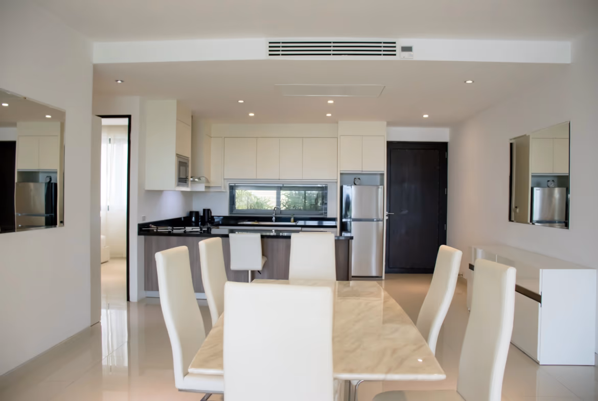 The photo shows a modern kitchen with a breakfast bar, stainless steel appliances, and a tiled backsplash.