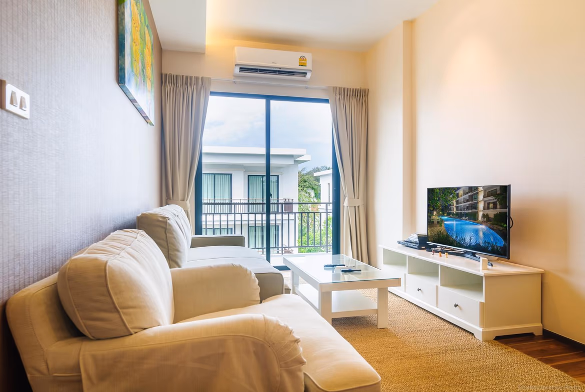 A spacious living room with modern furnishings and a view of the pool.