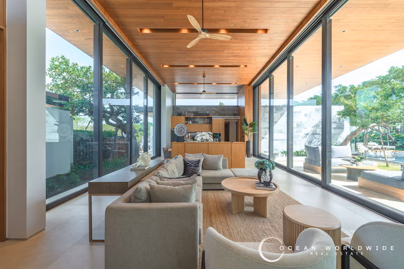 An exterior view of the villa includes a swimming pool, patio, and lush tropical landscaping.