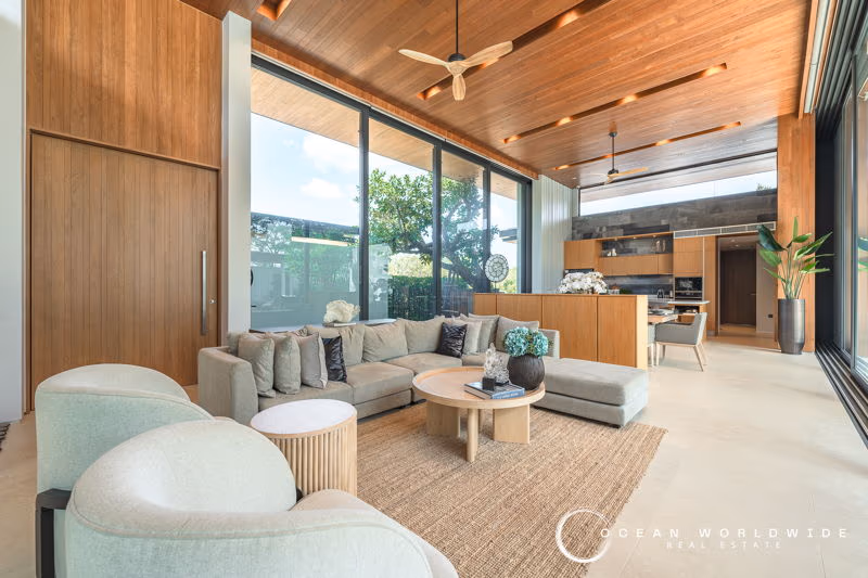 A spacious bedroom with a private balcony overlooking a tropical landscape.