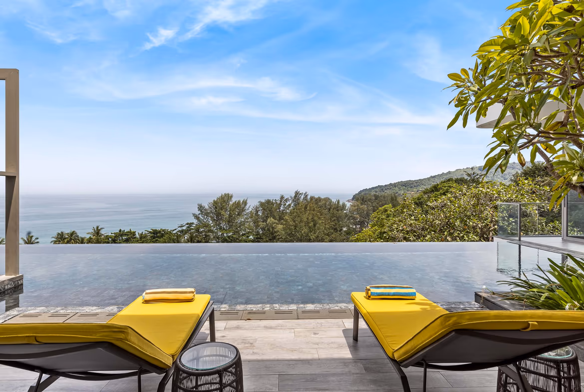 A spacious living area with modern furnishings and large windows showcasing an ocean view.