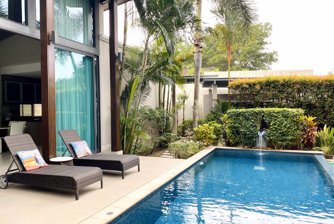 A spacious outdoor patio with a swimming pool and sun loungers.