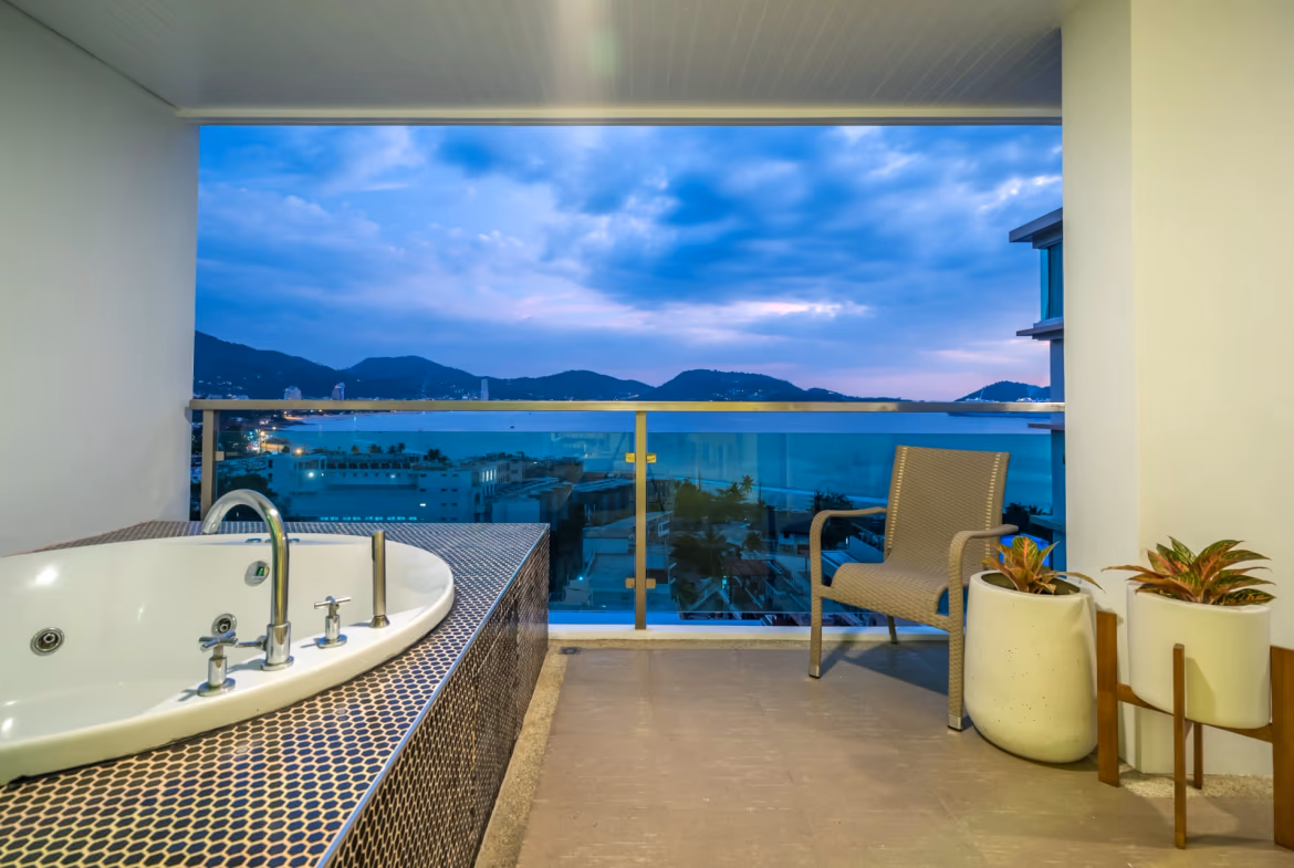 A balcony with a sea view and a patio table and chairs.