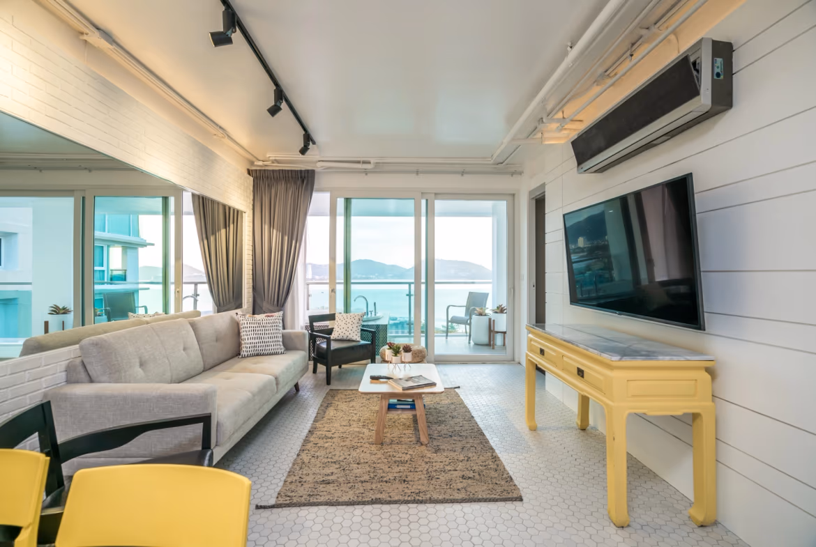 A modern bedroom with a large window offering a sea view.